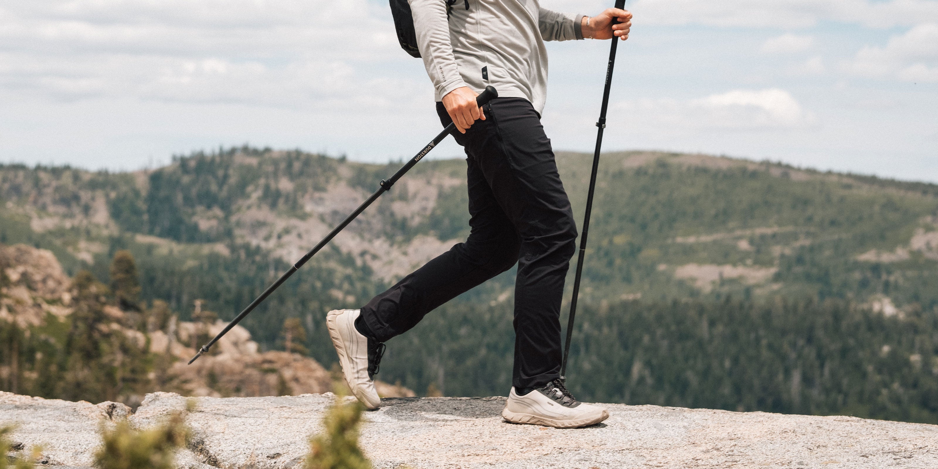 Hiker wearing black KETL Shenanigan Outdoor Pants on a mountain trail
